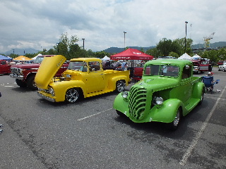 2013 Ford F-100 - A car show displays several vintage pickup trucks under a cloudy sky.
