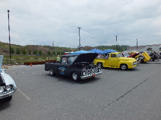 2013 Ford F-100 - Multiple classic pickup trucks are displayed outdoors, with some hoods open.