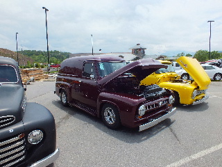 2013 Ford F-100 - A customized 1950s Ford pickup truck is displayed with its hood open at an outdoor event.