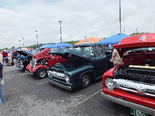 2013 Ford F-100 - Several classic pickup trucks are lined up at an outdoor car show, with their hoods open for display.
