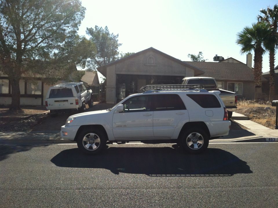 White Toyota 4Runner parked in driveway, another SUV in background