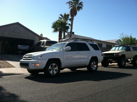 2003 Toyota 4Runner - A white 2003 Toyota 4Runner is parked on a residential street, with another lifted SUV behind it.