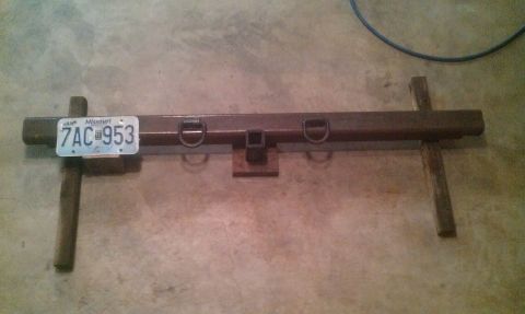 1987 Ford Bronco - A homemade trailer hitch receiver assembly with D-rings and a license plate is shown on a concrete floor.