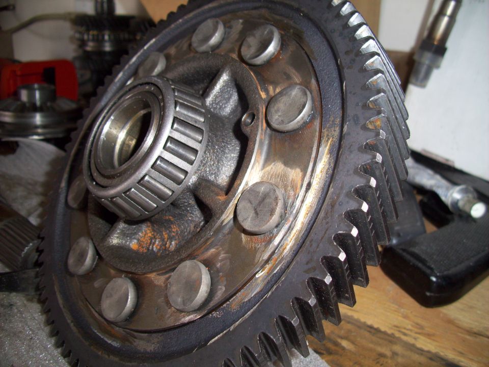 Differential gear with bearing and several bolts visible, Supermotors.net logo in corner