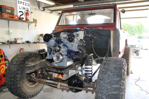 1968 Ford Bronco - 1968 Ford Bronco undergoing engine installation in a garage.