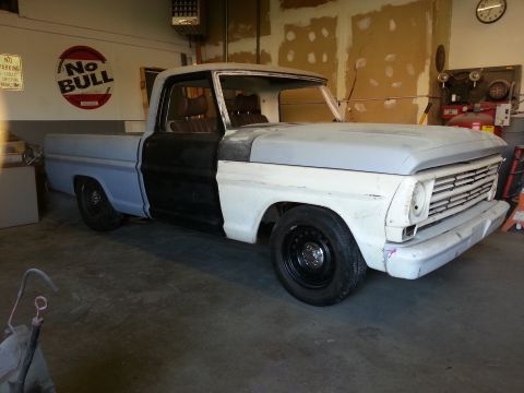 1967 Ford F-100 - This 1967 Ford F-100 pickup truck is undergoing restoration in a garage, showing primer and blue paintwork.