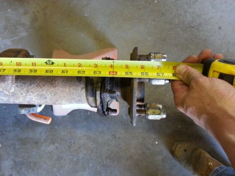 1967 Ford F-100 - A tape measure is used to measure a rear axle assembly, indicating a specific dimension for a vehicle part.