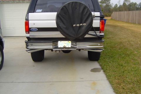 1993 Ford Bronco - Rear view of a 1993 Ford Bronco, showing its spare tire cover and dual exhaust pipes.