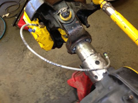 1988 Ford Bronco - This image shows a close-up view of a vehicle's suspension system, highlighting the brake caliper and associated plumbing.