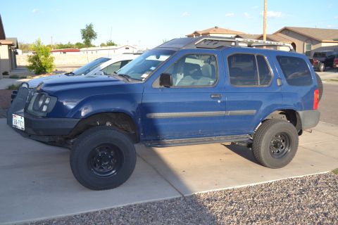 2004 Nissan Xterra - Side view of a blue 2004 Nissan Xterra SUV with aftermarket modifications.