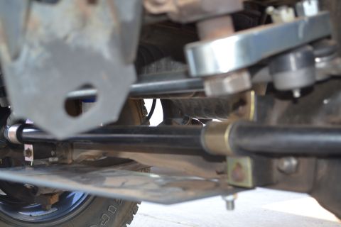 2004 Nissan Xterra - Undercarriage view of a vehicle's suspension system, focusing on the steering and sway bar components.