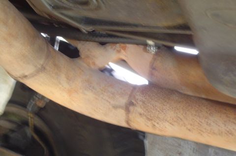1993 Ford Bronco - Close-up view of the underside of a vehicle, focusing on the exhaust system components.