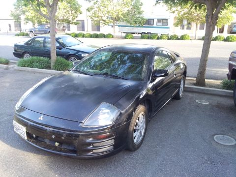 2001 Mitsubishi Eclipse - A black Mitsubishi Eclipse coupe is parked in a lot, showing its front-left side.
