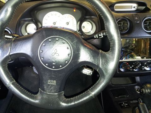 2001 Mitsubishi Eclipse - Interior view of a 2001 Mitsubishi Eclipse, showing the steering wheel, dashboard, and center console.