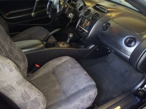 2001 Mitsubishi Eclipse - The interior of a 2001 Mitsubishi Eclipse is captured, highlighting the driver's seat and dashboard area.