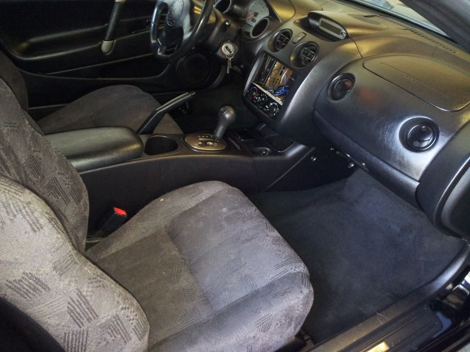 Interior of a 2001 Mitsubishi Eclipse, showing the dashboard, seats, and center console