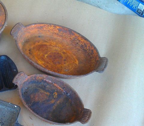 1989 Ford Bronco - Two old, rusty cast iron pans are shown from a top-down perspective on a neutral surface.