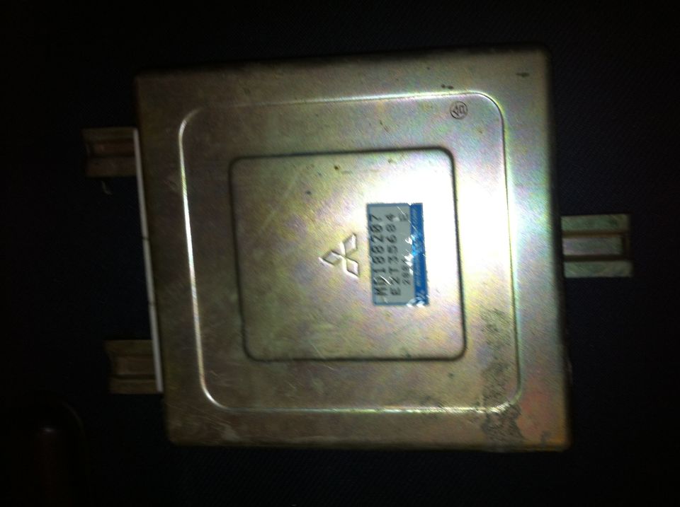 Mitsubishi engine control unit with part number MD188287 visible on a blue label