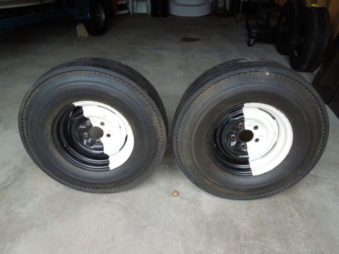 1994 Ford Bronco - A pair of tires with wheels, half painted black and half white, sit on a concrete surface.