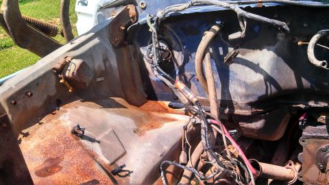 1979 Ford Bronco - The engine bay shows significant rust and exposed wiring, with various hoses and metal parts visible.