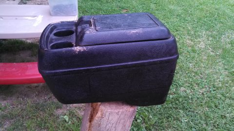 1979 Ford Bronco - This center console, likely from an older vehicle, features dual cup holders and a hinged storage compartment.