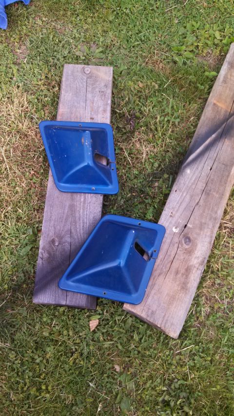 1979 Ford Bronco - Two blue plastic door panels are shown on wooden planks outdoors.
