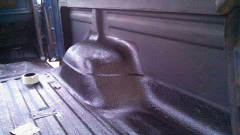 1979 Ford Bronco - Spray-on bed liner being applied to the interior of a truck bed.