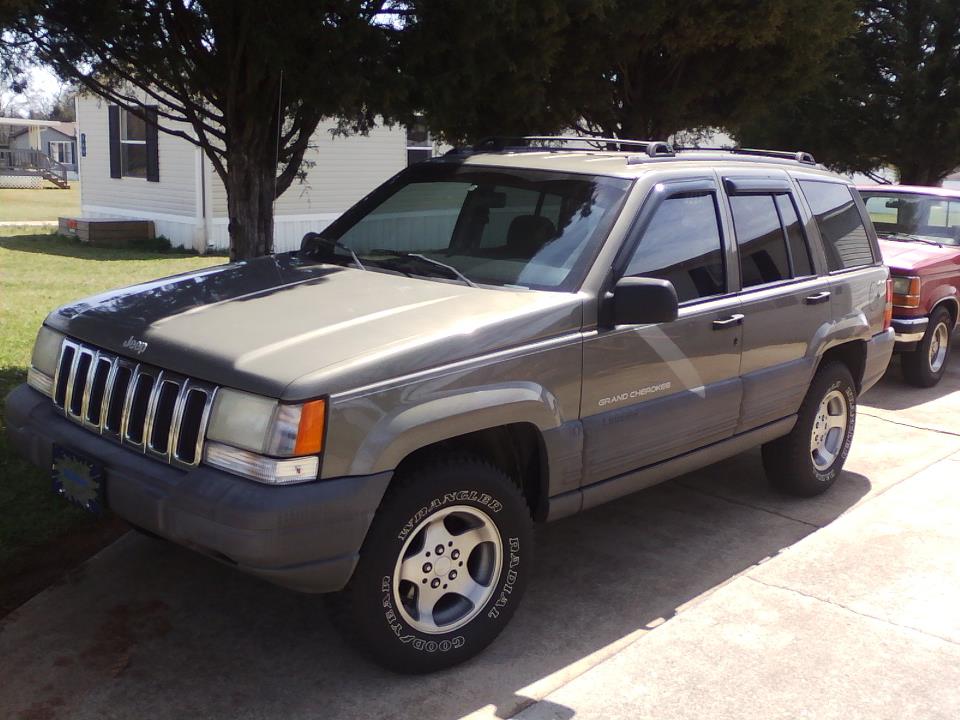 Jeep Grand Cherokee parked in driveway next to another SUV