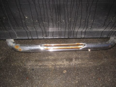 1993 Ford Bronco - Close-up of a rusted chrome step bar on the side of a vehicle.