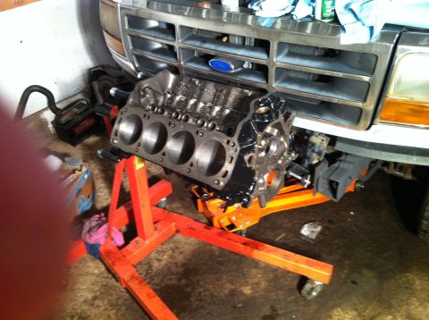 1992 Ford Bronco - Engine block on stand before a 1992 Ford Bronco's front end.