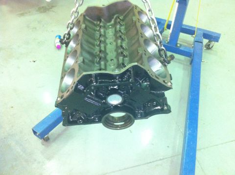 1992 Ford Bronco - An engine block is suspended by chains, with a blue engine stand providing support.