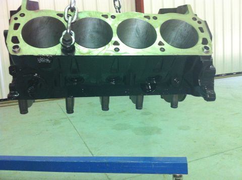 1992 Ford Bronco - This is a close-up view of an engine block, suspended by chains, with its cylinder bores clearly visible.