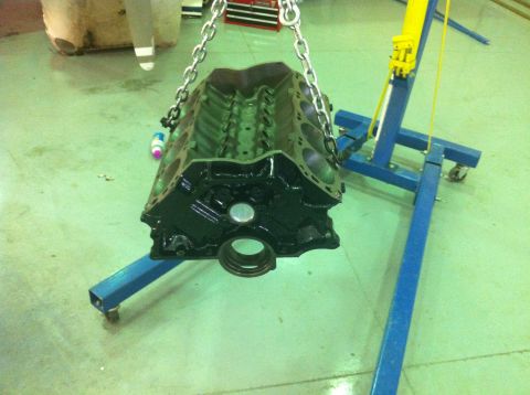 1992 Ford Bronco - Engine block being lifted by a chain hoist, likely for a rebuild or installation.