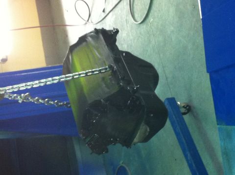 1992 Ford Bronco - Part is suspended by chains, undergoing a coating process.