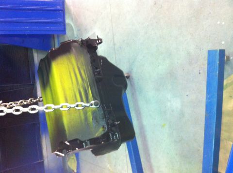 1992 Ford Bronco - A black and yellow engine block is shown hanging from a chain, likely in a workshop or paint booth.