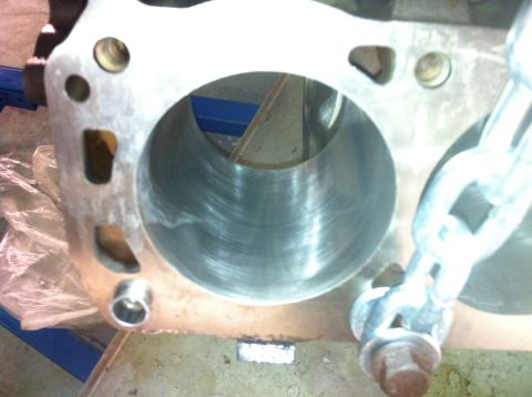 1992 Ford Bronco - Close-up of an engine cylinder block, showing the interior of a cylinder bore and a chain attached to the exterior.