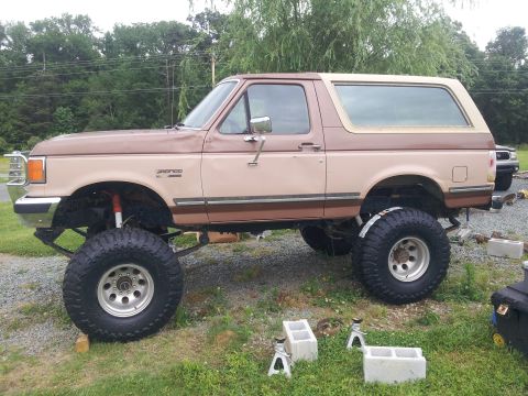1988 Ford Bronco - This lifted 1988 Ford Bronco is shown from the side, resting on blocks and jack stands.