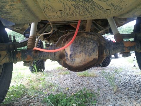1988 Ford Bronco - Underside view of a vehicle's rear axle and suspension components.