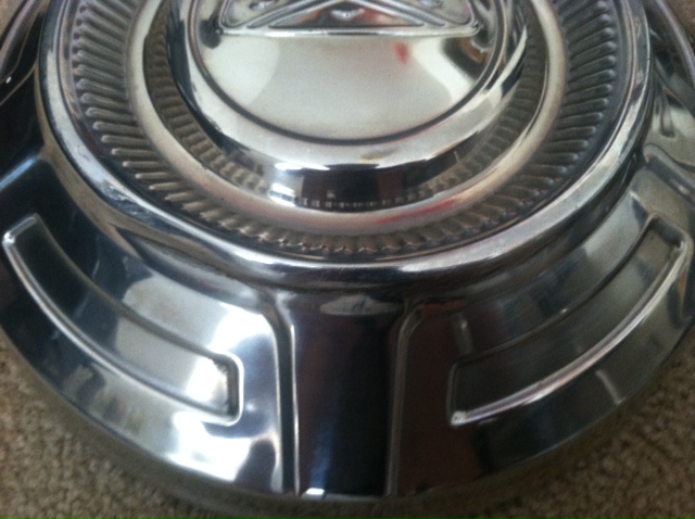 Chrome hubcap with ribbed outer edge and raised center emblem