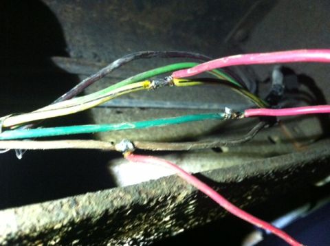 1977 Ford F-350 - A close-up view shows a collection of spliced wires, some with pink and green insulation, indicating electrical work.