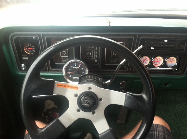 Interior view of a 1977 Ford F-350 with aftermarket gauges and steering wheel