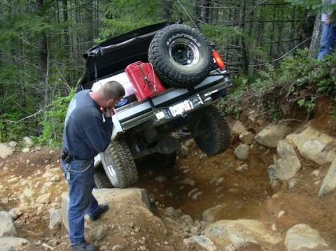 1995 Ford Bronco - A man inspects a Ford Bronco navigating a challenging off-road trail.