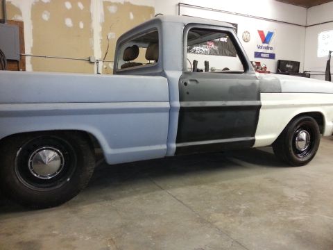 1967 Ford F-100 - This 1967 Ford F-100 truck is seen from the side, showing its current state of restoration with primer and white paint sections.