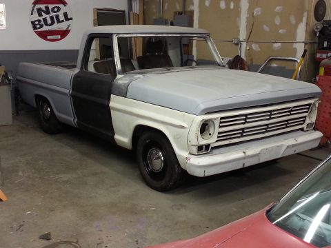 1967 Ford F-100 - This 1967 Ford F-100 pickup truck is shown in a garage, appearing to be in a state of repair or restoration.