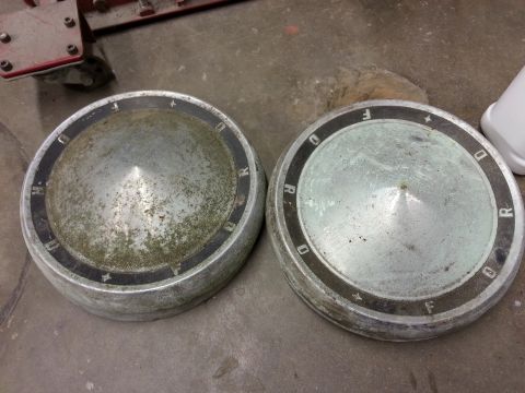1967 Ford F-100 - Two vintage Ford hubcaps are shown, one with some green discoloration.