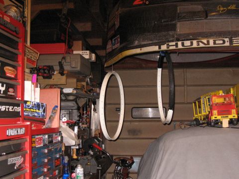 1994 Ford Bronco - A cluttered garage scene with various tools, parts, and toys visible.