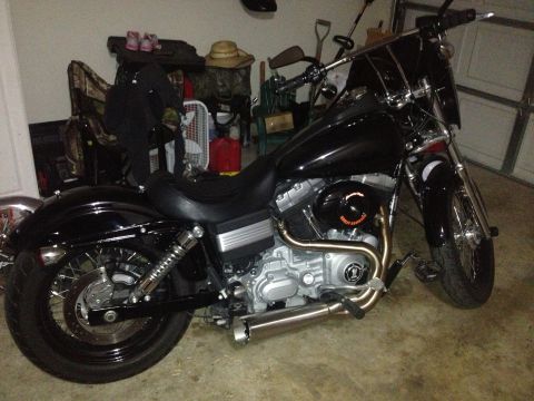 1995 Ford Bronco - A black motorcycle is parked in a garage with various items in the background.