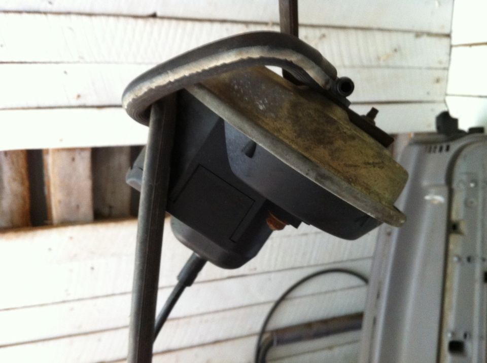 Vehicle air intake housing with hose attached, mounted on a metal stand