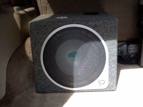 1995 Ford Bronco - A subwoofer is installed in the cargo area of a vehicle, with visible interior trim and carpeting.