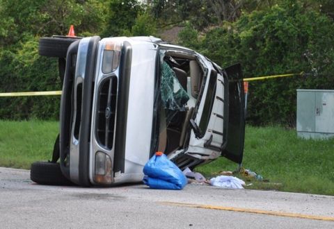 1999 Ford Ranger - A white SUV has overturned on the side of the road, with debris scattered around it.